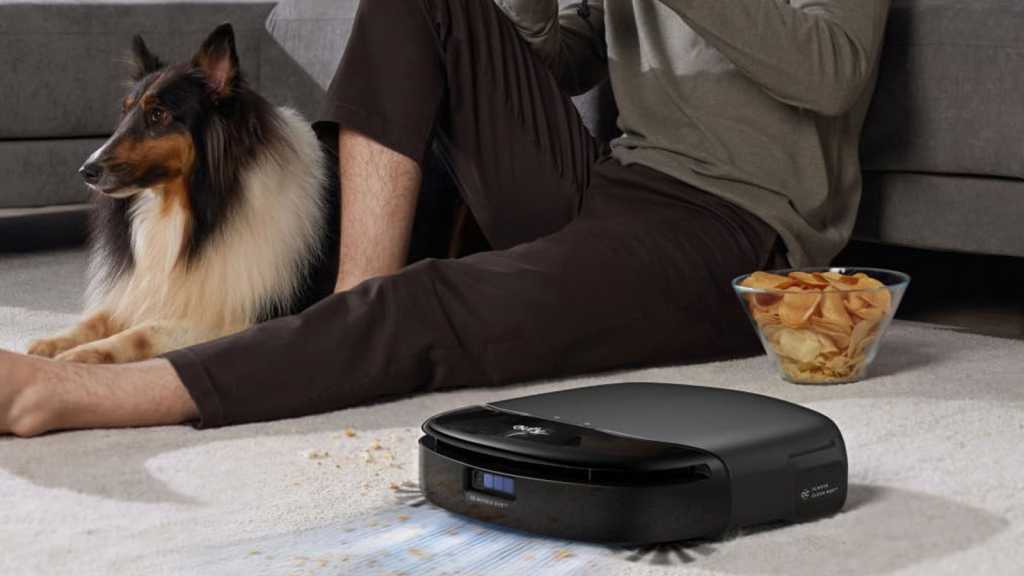 Eufy robot vacuum cleaning near a man and a dog